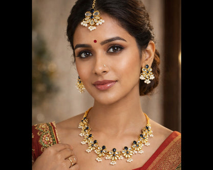 Woman wearing traditional jewelry and a red saree with gold details.