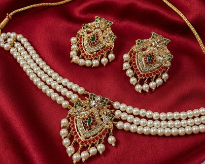 Pearl necklace and earrings set on a red fabric background