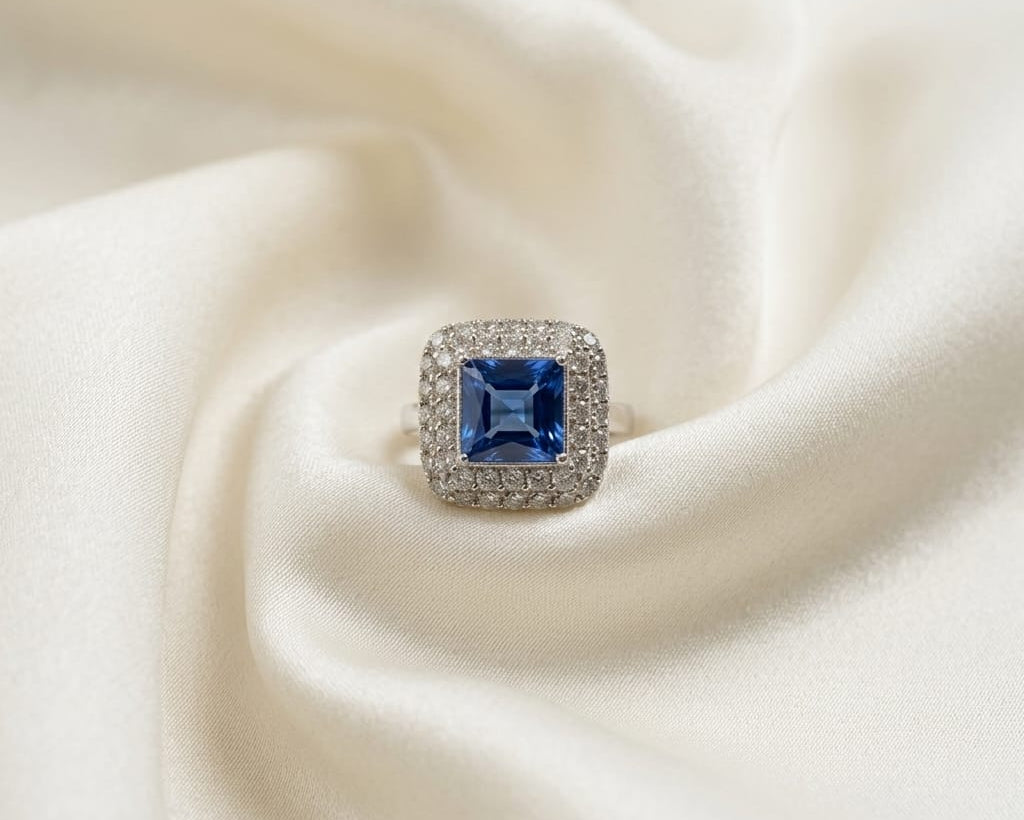 Silver ring with a blue gemstone on a white fabric background