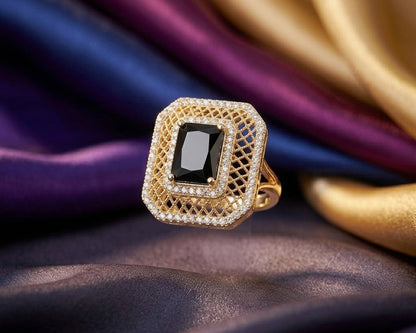 Gold ring with a black gemstone on a fabric background