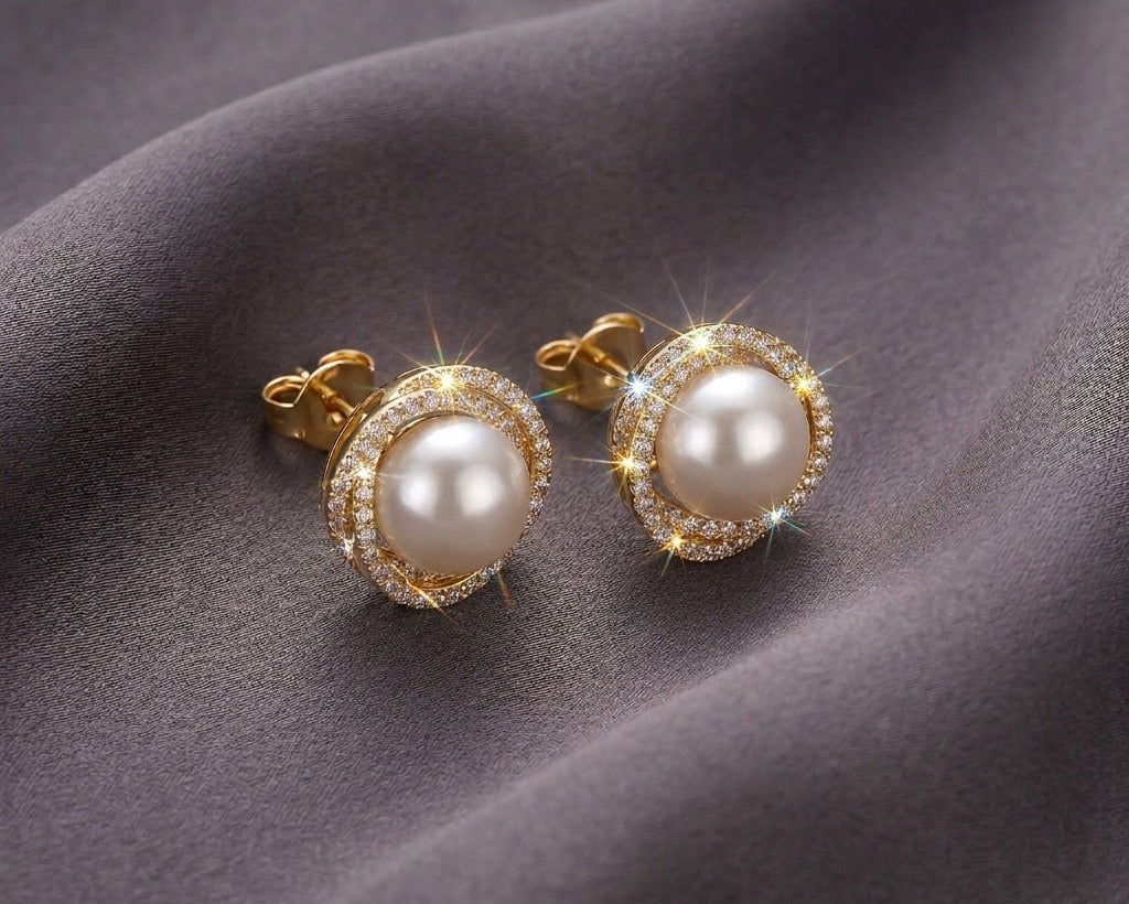 Pearl earrings with gold accents on a gray fabric background