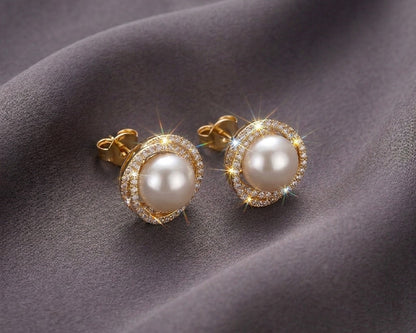 Pearl earrings with gold accents on a gray fabric background