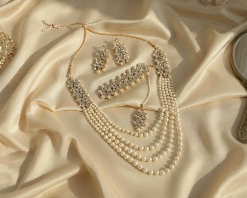 Pearl necklace and earrings set on a satin surface