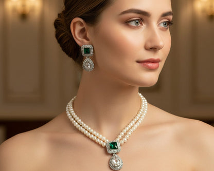 Woman wearing a pearl necklace and emerald earrings with a blurred background