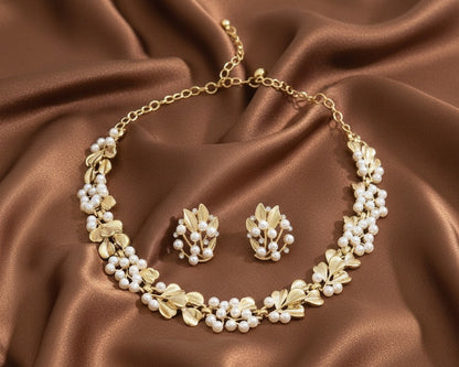 Gold necklace and earrings set on brown satin fabric