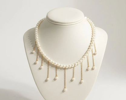 Pearl necklace on a white mannequin bust against a light gray background